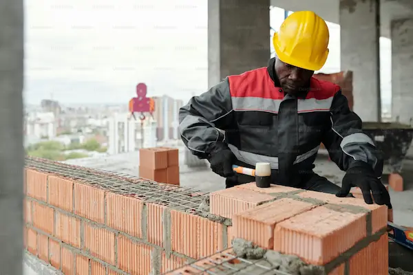 Brick mason construction worker building wall